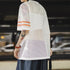 Person wearing a white mesh shirt with orange accents in an indoor setting
